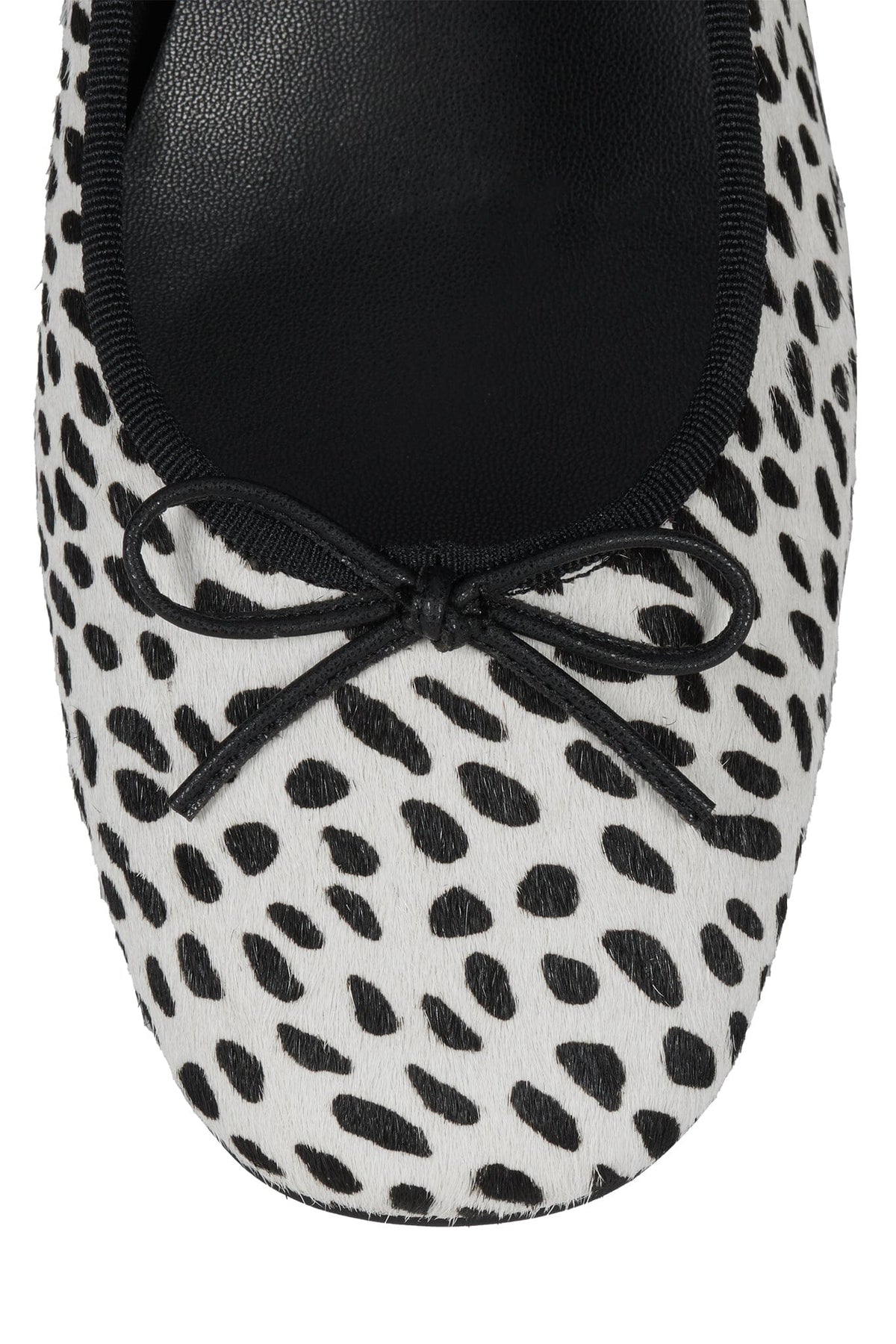 Leopard print ballet flat with a rounded toe and black bow detail across the upper in white and black spotted fabric