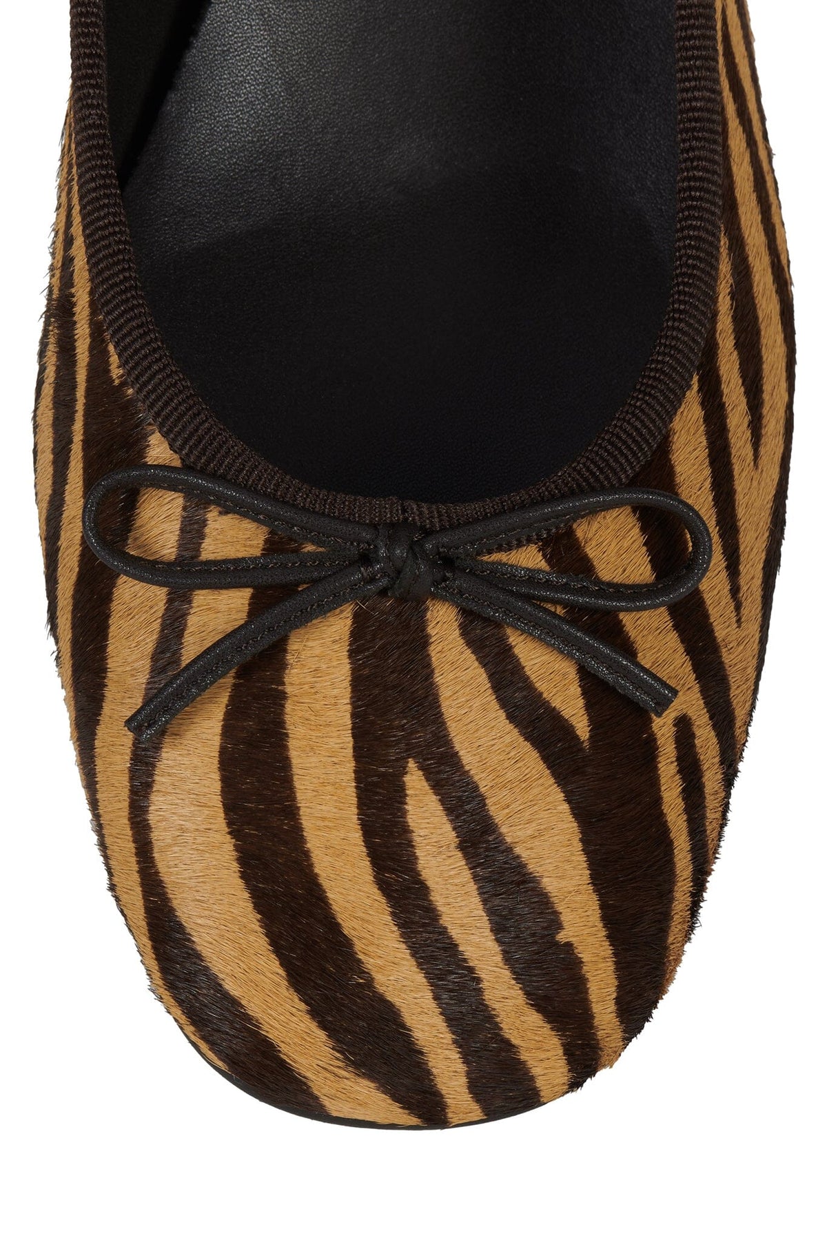 Zebra print flat shoe with a rounded toe black trim and decorative bow detail on the vamp and soft textured upper