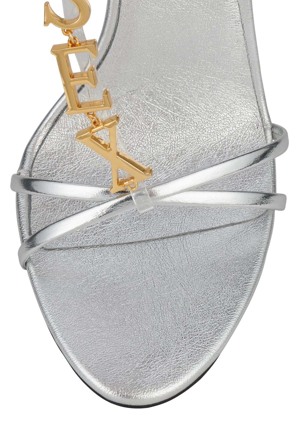 Silver open toe sandal with thin crisscross straps and a textured finish, accented by a gold letter charm embellishment and softly rounded toe.